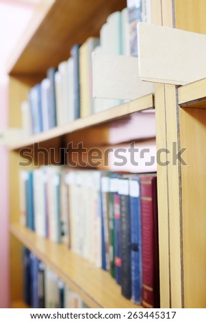 Books in a row. Bookshelf in public library.