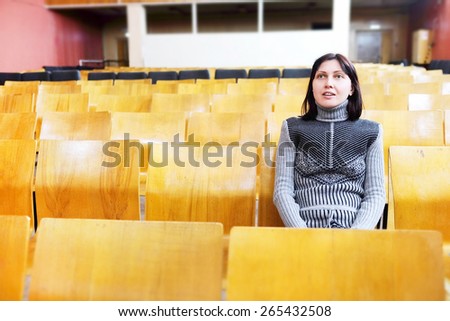 Surprised woman sitting in the retro cinema