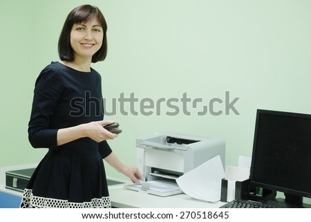 Secretary in office working on printer