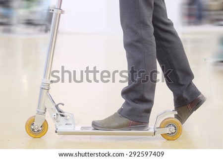 The adult man on a kick scooter