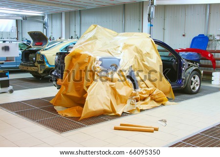 The image of cars stand under repair in body shop