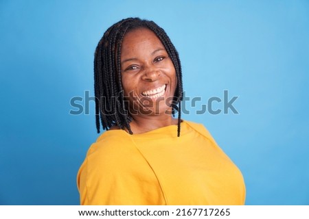 portrait of smiling black woman in yellow sweater isolated on blue background Foto stock © 