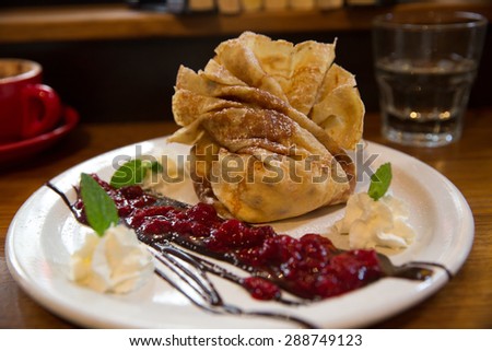 Crepe parcel stuffed with  vanilla ice cream, whipped cream, mixed berries and chocolate sauce.