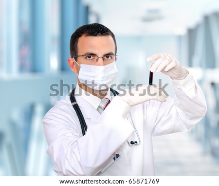 Friendly doctor -intern resarch a medical test glass with blood .
