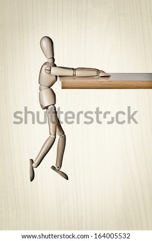 Hanging on for dear life: Manikin, anatomical model, hanging off a ledge