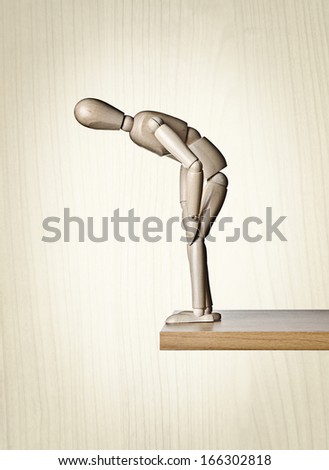Looking over the edge, Manikin, anatomical model, placed on the edge of a board