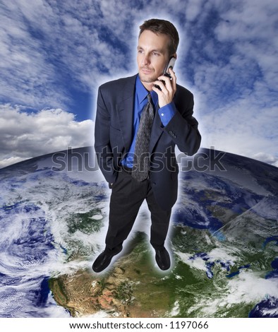 Businessman on top of earth making a cellular phone call.