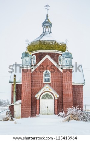 An old red brick church in a winter storm