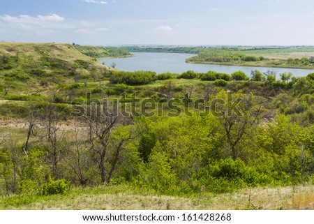 A river flowing through the flat landscape of the prairies.