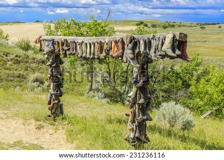 The hanging cowboy boots at the Great Sand Hills near Sceptre, Saskatchewan.  These old hanging boots are a memorial to John Booth who was a local rancher and lived in the area his entire life.