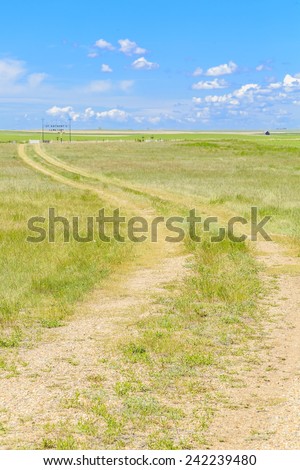 The dirt road leading to a grave yard on the open prairie.