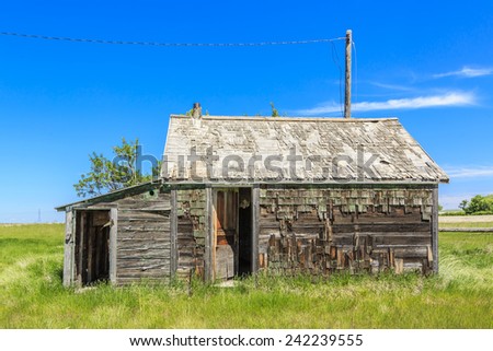 An old abandoned farm house with weathered wood and paint.