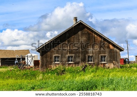 Similar – Image, Stock Photo A few wooden huts and many bushes and trees are standing around on a hilly green meadow landscape in the nature park Ammergau Alps in Upper Bavaria and a piece of bicycle path can be seen as well.