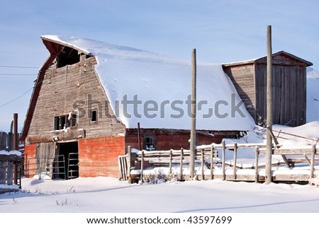 Old rustic red barn in a winter wonderland.