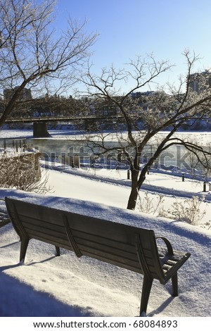 Bench along the icy cold waters of the Saskatchewan River in Saskatoon, Canada