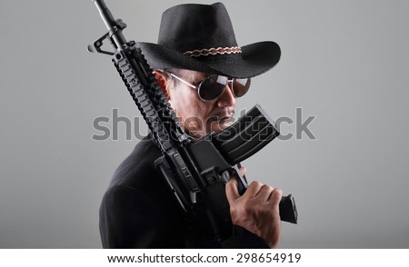 An old gangster and his machine gun, over grey background