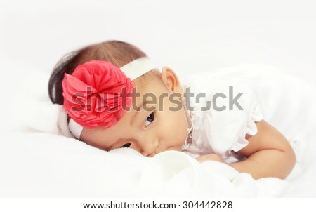 Portrait of sleepy baby lying in bed over white background with soft color tone