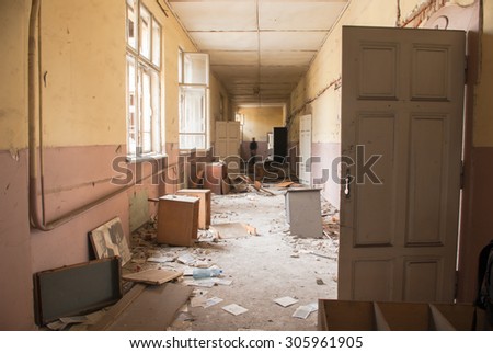 Abandoned corridor with dark figure is seen in an old school building Sofia, Bulgaria, May 12, 2014. Some of the doors and windows had been wrecked. Thick layer of dust is all over the place.