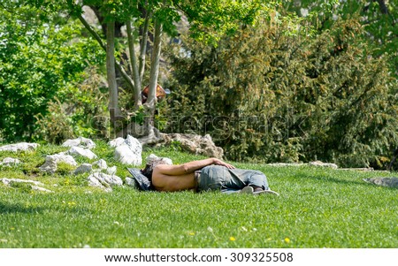 A half-dressed homeless man is sleeping on the grass in the City garden park in Sofia, Bulgaria, April 27, 2015.  Poverty is still of the biggest issues in Bulgaria, member of EU since 2007.