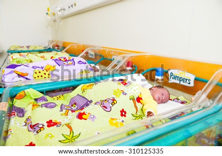 Newborn innocent-baby sleeping in tiny bed in the newborns compartment in the Obstetrics and Gynecology Hospital \