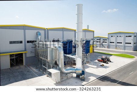 Sofia, Bulgaria, September 14, 2015 - General view of a recycling waste to energy and composting factory with bio gas chimney pipeline installation and silo for recycled waste material from outside.