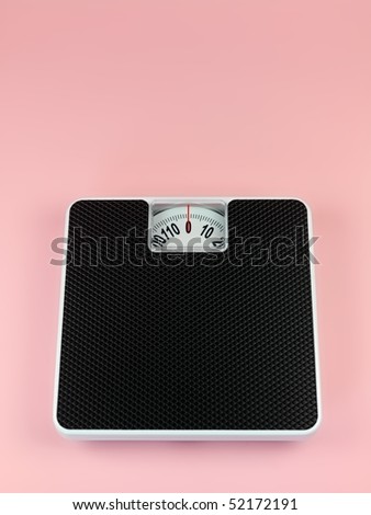 A set of bathroom scales isolated against a pink background