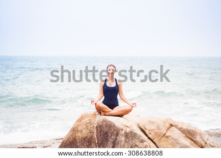 Woman Sitting in the Lotus Position on the Rock Above the Sea and Meditating. Yoga Outdoor, Thailand