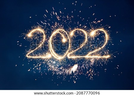 Happy New Year 2022. Beautiful creative holiday background with fireworks and Sparkling font 2022
