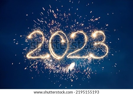 Photo of Happy New Year 2023. Beautiful creative holiday background with fireworks and Sparkling font 2023