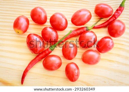 tomatoes place on wood like heart pattern with chili