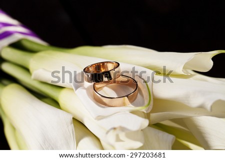 a wedding rings and a bouquet of white lilies