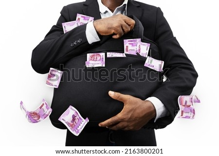 Businessman holding black bag full of Indian rupee notes isolated on white background, money falling from bag Foto d'archivio © 