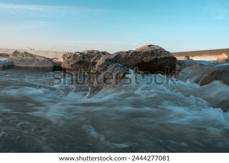 Similar – Image, Stock Photo Further wet beach in the shimmer of the sunset. Waves, clouds and people in the distance.