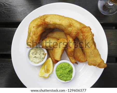 Fish and chips served with french fries, mushy peas and tartar sauce