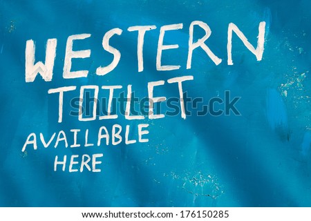 Western toilet available here sign, painted in white on blue background