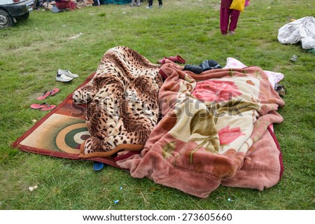 KATHMANDU, NEPAL - APRIL 26, 2015: People sleeping under blankets on an open ground at Chuchepati on the morning after the 7.8 earthquake on 25 April 2015.