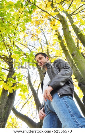 Young man standing in a forest during the fall season