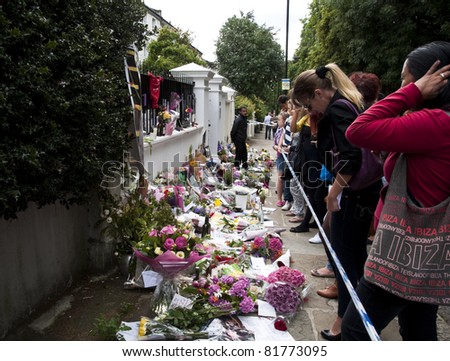 LONDON - JULY 27: Her fans pay tribute to Amy Winehouse in front of her house on Camden square, on July 27, 2011 in London. Amy Winehouse died aged 27 on Saturday, July 23.