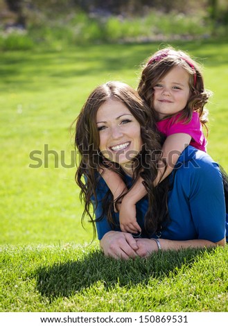 Smiling Happy Mother and daughter playing outdoors together