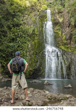 Man hiking to a beautiful tropical waterfall