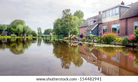 river / canal in the Netherlands with traditional dutch houses on the waterside which are giving a beautiful reflection on the watersurface
