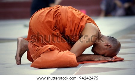YANGON, MYANMAR - NOV 15: An unidentified buddhist monk kneels down in prayer on Nov 15, 2011 in Yangon, Myanmar.