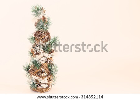 Holiday Christmas tree with pine cones and fur needles on warm off white background