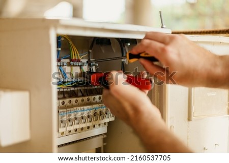 Close up of electrician hands who fix the electric box on construction site ストックフォト © 