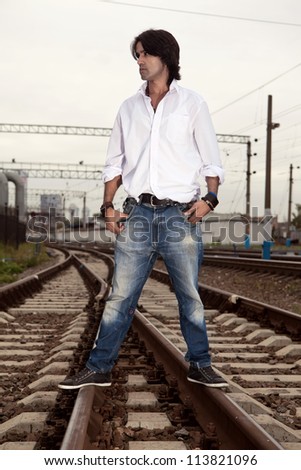Man in the white shirt is standing on the rails