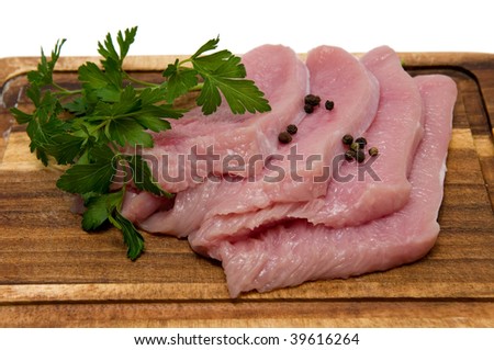 Raw meat fillet of a turkey on wooden board, is isolated on  white.
