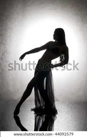 Silhouette of the beautiful woman dancing on glass.
