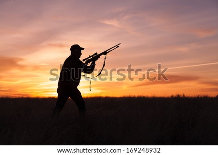 Rifle Hunter Silhouetted in Beautiful Sunset