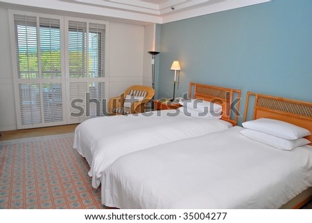 Twin beds with table lamps lighted up in a high class hotel room