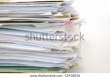 Stack of files full of documents signifying concepts such as work and stress, and business objects.